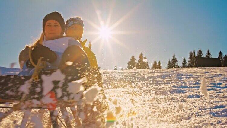 两个女人和狗在雪坡上滑雪橇玩得很开心