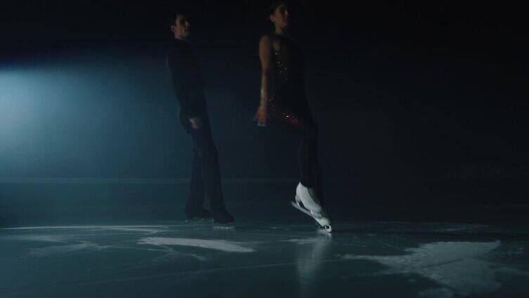 在比赛开始前，一对年轻的花样滑冰艺术夫妇正在冰场上表演双人花样滑冰的舞蹈。完美，精确，自由，激情的理念。