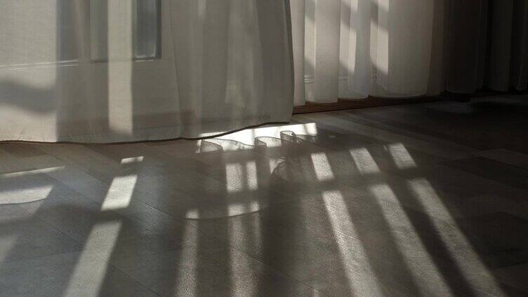 平静的清晨，太阳升起，透过窗户洒下阳光。光线从表面反射，而窗帘在轻柔的舞蹈中移动。