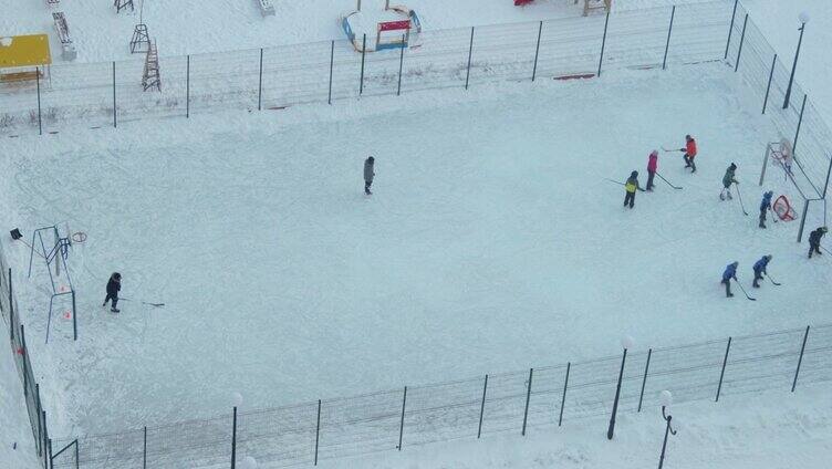 孩子们在院子里的溜冰场上打曲棍球