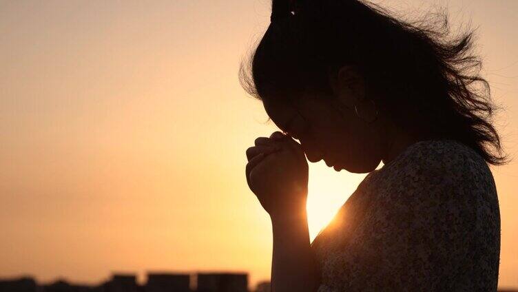 女人在阳光下祈祷