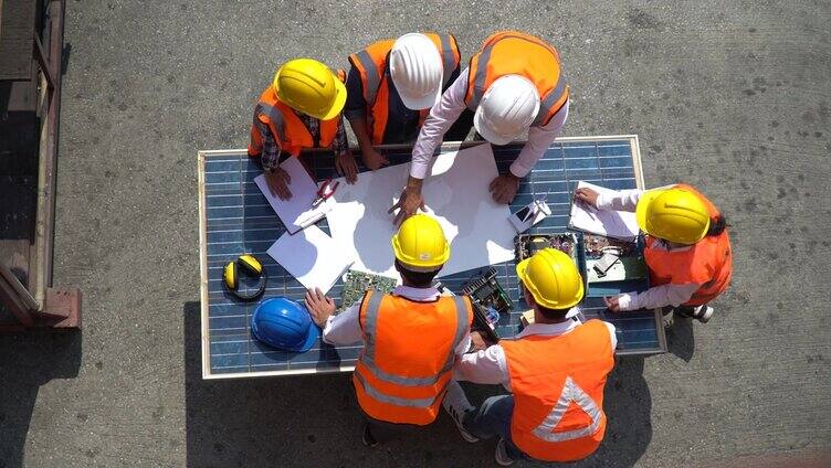 太阳能电站工程师小组会议和讨论，讨论太阳能电池的蓝图，在建筑工地户外规划一个新的环境电力项目