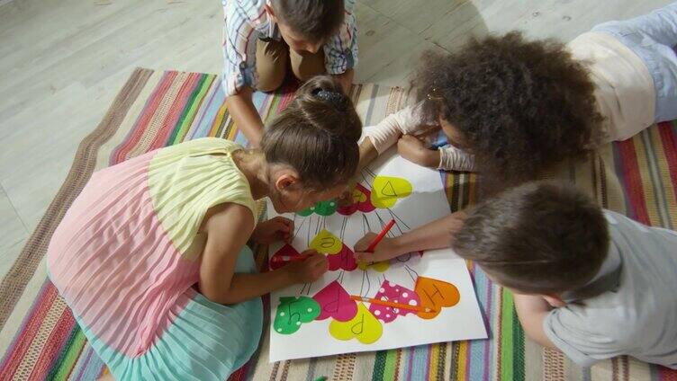 幼儿园小朋友在手工海报上画画