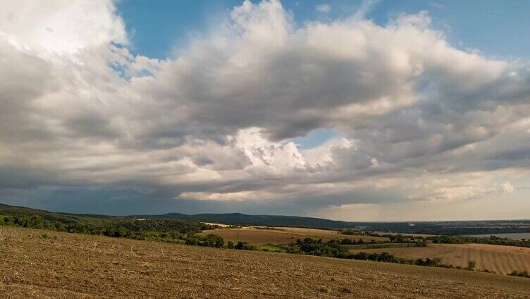 雨云掠过乡村山丘和麦田