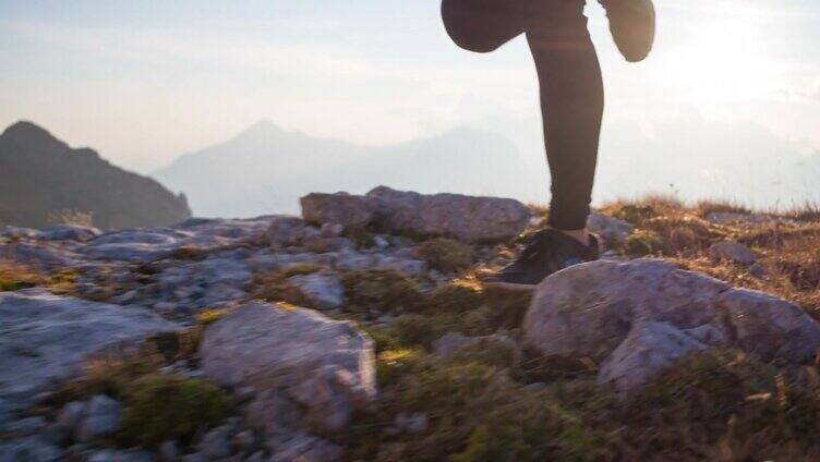 在山上跑步，在夕阳的照耀下看运动员的双腿