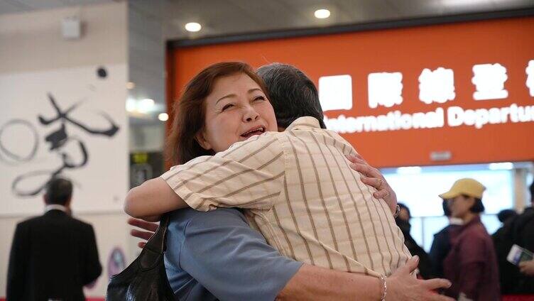 一对中国老年夫妇在机场拥抱
