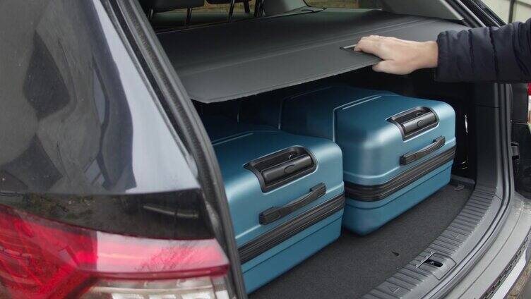 男人把所有的旅行袋都放在他车的后备箱里