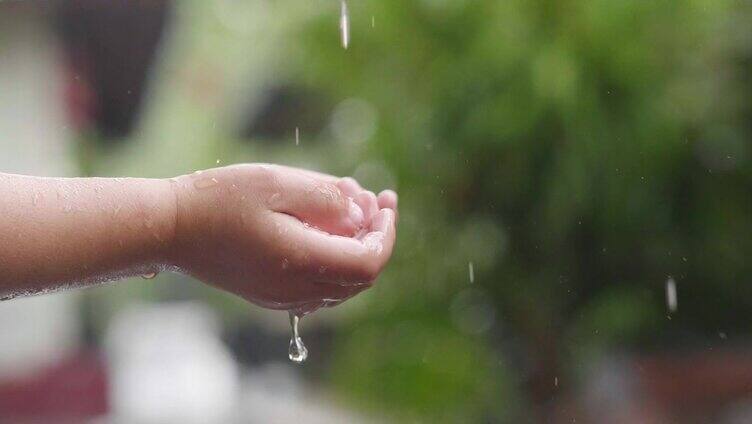 一个孩子把手放在雨里的特写