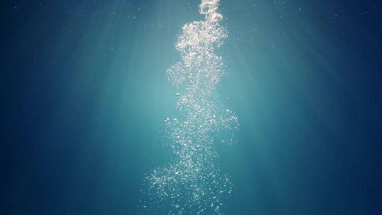 美丽的水下阳光光束与上升的气泡幕