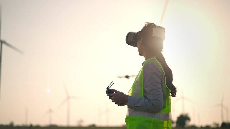 一名亚洲女工程师操控无人机飞过风力涡轮机