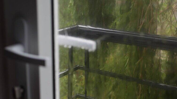 强烈的雨水冲在窗玻璃上，流下来。特写镜头。雨点落在玻璃背景的雨季。4 k