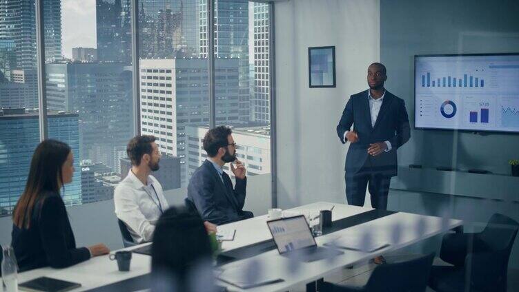 多元化办公室会议室会议:魅力黑人数字企业家向一群投资者展示电子商务金融科技产品。墙壁电视与大数据分析，信息图表，统计