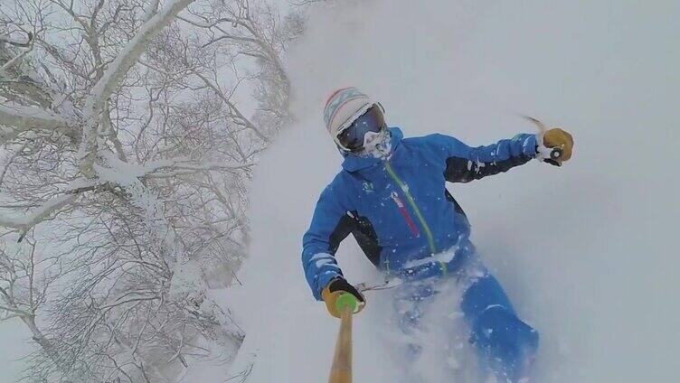 自拍:一名年轻的免费滑雪爱好者在日本山区的深雪中滑雪。