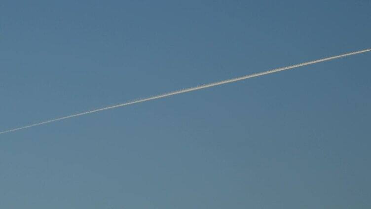 喷气式飞机在蓝天上留下白色的尾迹