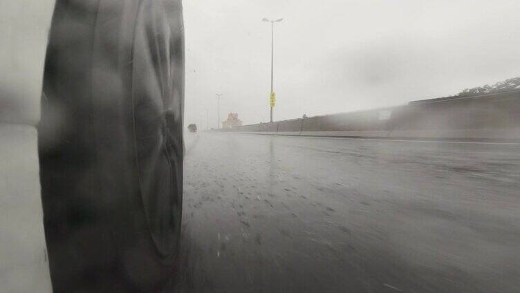 下雨天在高速公路上开车。汽车轮胎飞溅的水