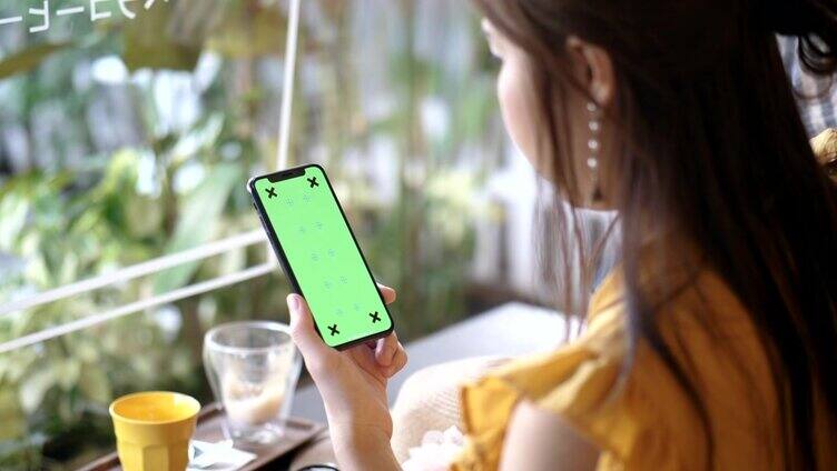 女人使用绿色屏幕的手机