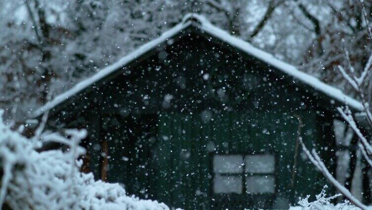 电影拍摄的暴风雪覆盖一个小木屋周围的自然