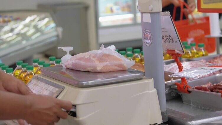 工作人员在超市用电子秤测量食物。