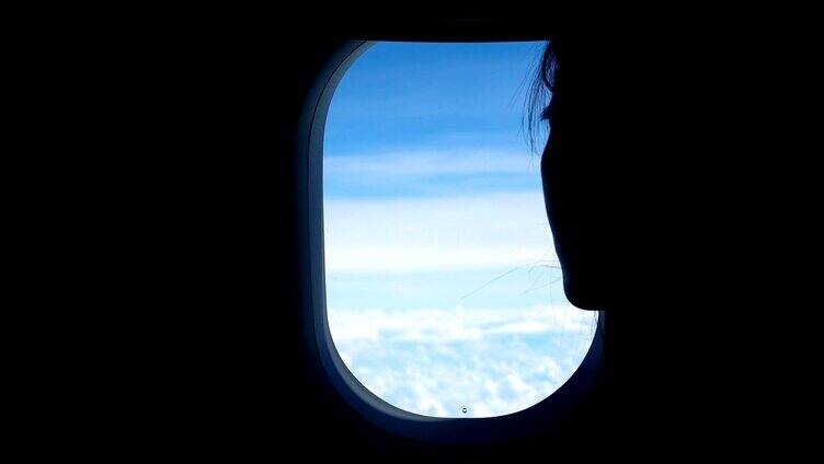 从飞机窗户往外看的女人