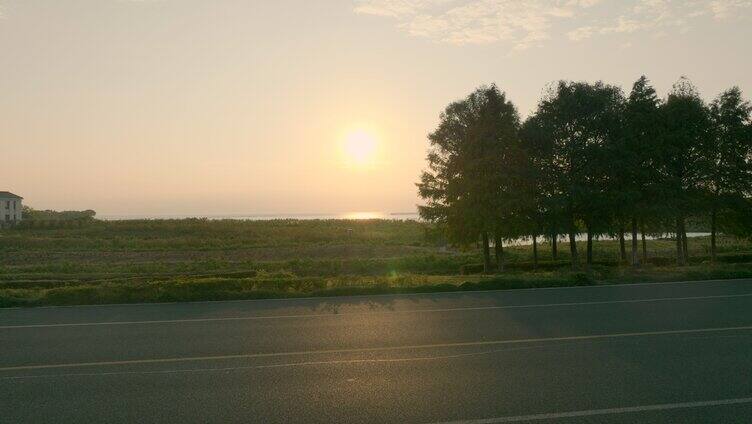 夕阳下环湖公路车辆行驶