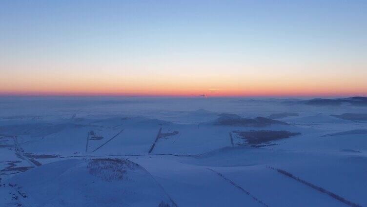 航拍浓郁夕阳下的垦区雪原