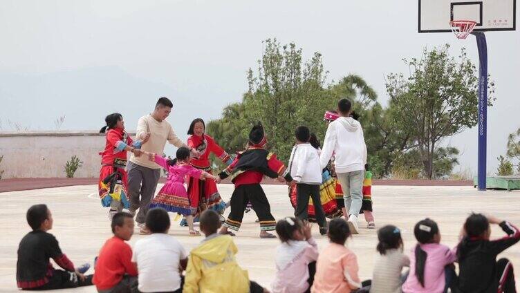 老师带少数民族小孩跳舞