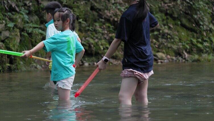 俩小女孩溪水里玩水枪滋水特写