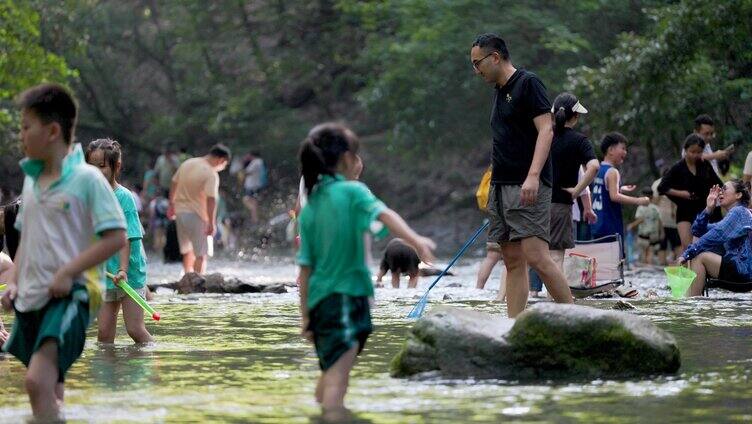 夕阳下的人们在山涧溪流玩水 戏水