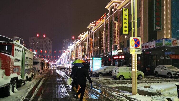 雪天夜晚行走的路人背影