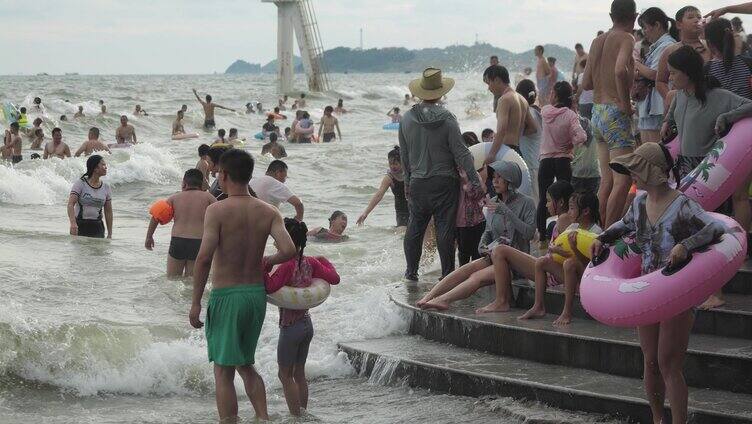 海浪冲向海岸海中人们在游泳