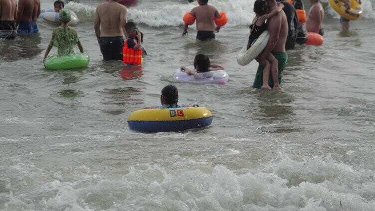 海浪冲向海岸海中人们在游泳