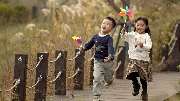 孩子举风车奔跑快乐童年开心快乐