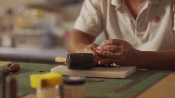 接近亚洲中国高级男子工作在他的工作室手工皮革表带皮革工艺