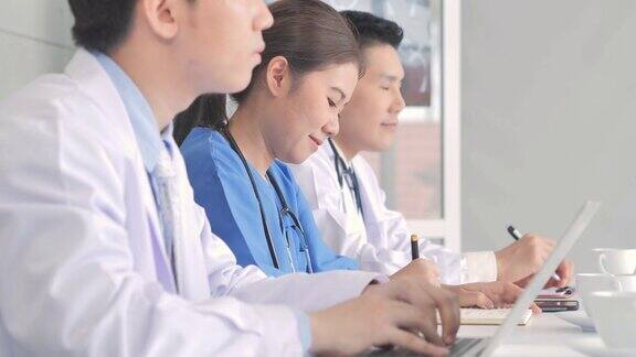 小组亚洲医生在会议上发言青年实习生在医学会议上听医生讲课成人教育