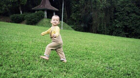 小男孩在春天的草坪上玩耍和奔跑
