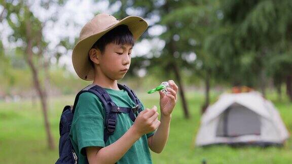 一个男孩正在观察他捉到的昆虫