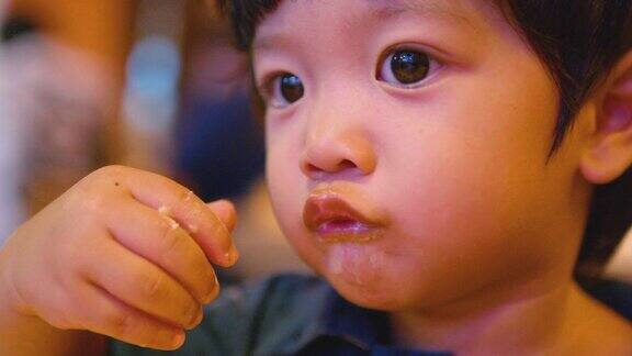 快乐的亚洲男孩用手吃日本面条美味的