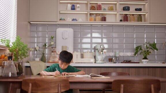 一个小男孩在家做作业的照片