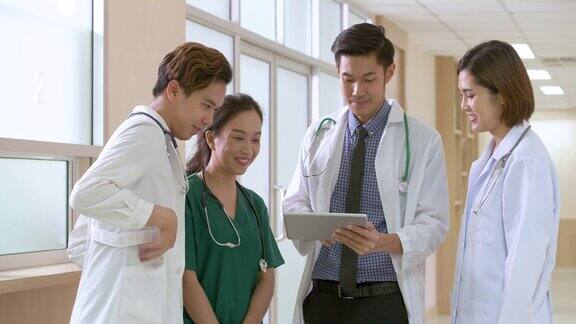 亚洲医生站在医院里微笑着谈论治疗病人