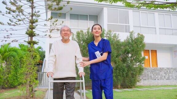 亚洲年轻的护理护士支持年长的男性在户外行走专科女医生帮助和照顾老年成年男病人在疗养院的公园做物理治疗