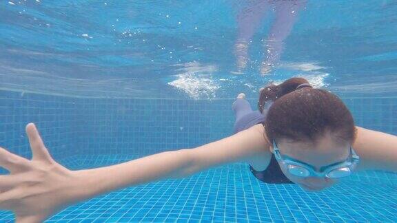 亚洲女性游泳和放松在度假村酒店的游泳池在海边的周末假期快乐旅行