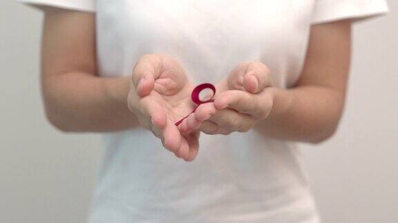 手握红丝带为12月的世界艾滋病日多发性骨髓瘤癌症宣传月和全国红丝带周保健和世界癌症日