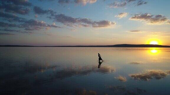 日落时在湖面上跳舞的芭蕾舞演员