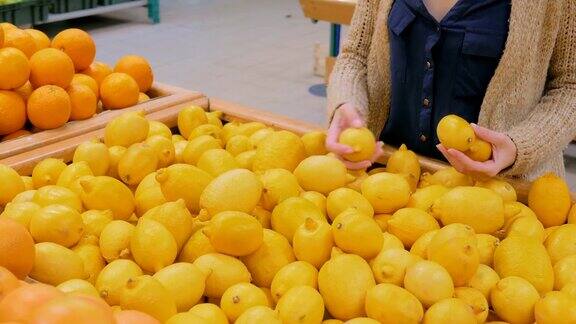一个女人在杂货店买新鲜的黄色柠檬