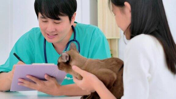 亚洲少女与宠物听亚洲男子兽医在门诊咨询她采购产品兽医关系人保健和医学宠物爱
