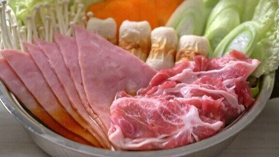 素喜烧或涮锅黑汤有肉、生的和蔬菜-日本料理风格