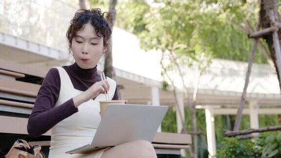 亚洲女商人坐着工作用笔记本电脑联系在线会议