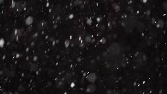 美丽真实的雪花孤立在黑色背景4K慢动作用长焦镜头完美散景拍摄无分级的镜头合成运动图形大的和小的雪雪花孤立的雪花