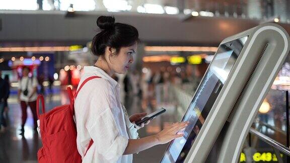 一名亚洲女性在机场使用登机机领取登机牌