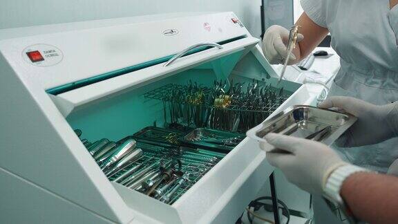 牙医将无菌器械从烘干机放入托盘中